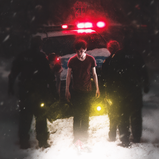 A young man in a red shirt is surrounded by police officers near a police car with flashing lights.